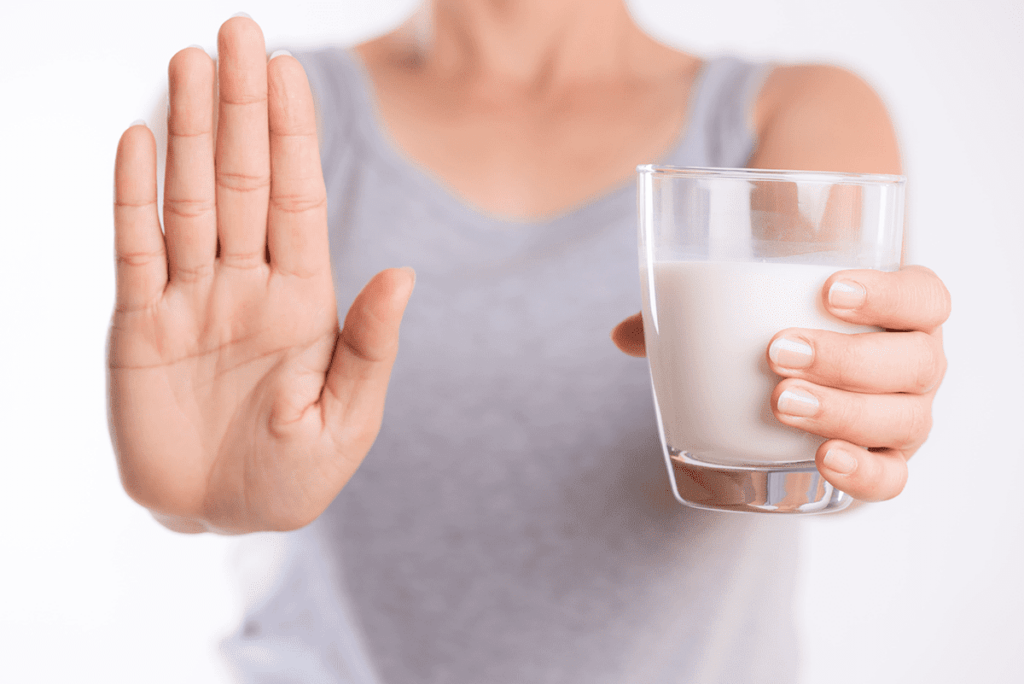 Mani di donna con un bicchiere di latte in mano